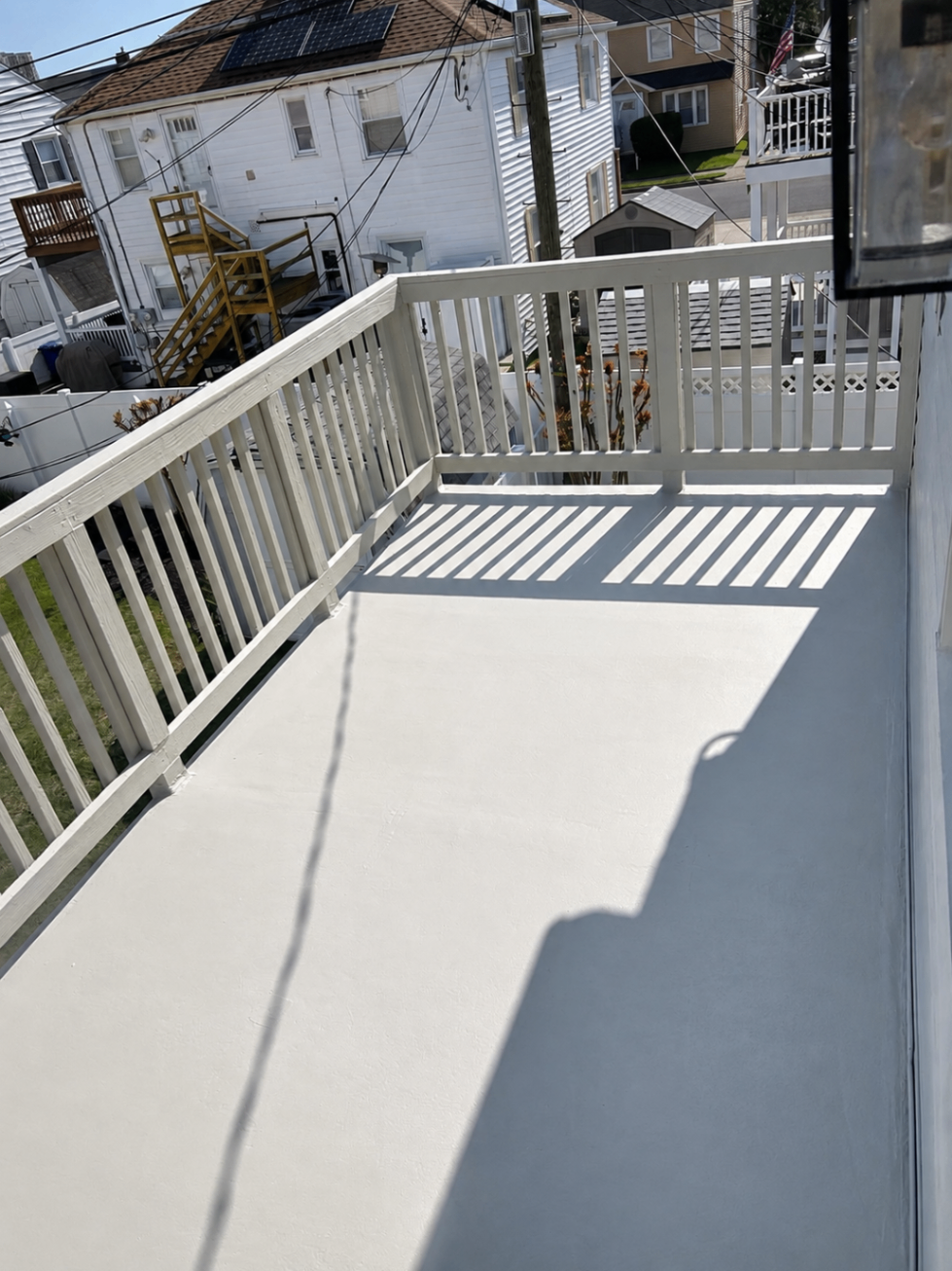 Balcony deck coated in white with freshly painted railings
