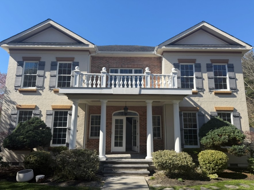 Same stucco home exterior with faded paint before the job
