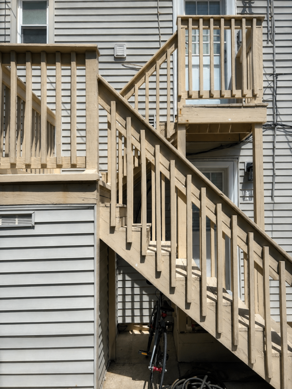 Bare weathered wood exterior stairs and railings before painting